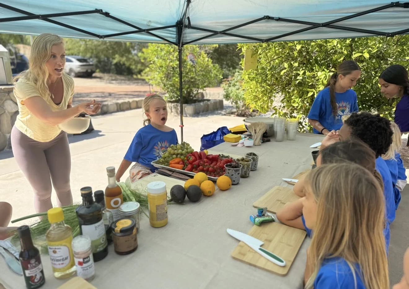 Children preparing food together at an outdoor table