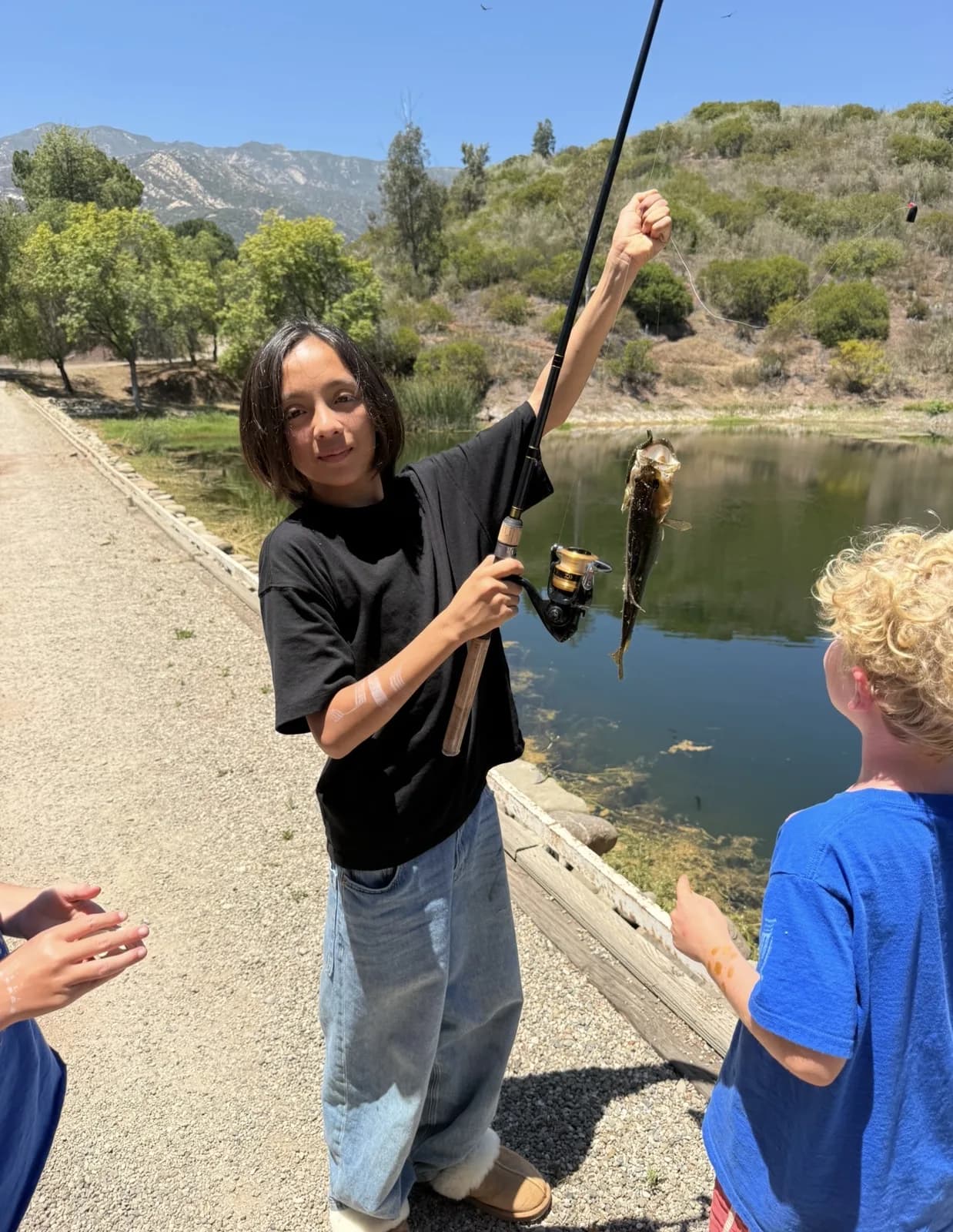 A child showing a fish during a pond study