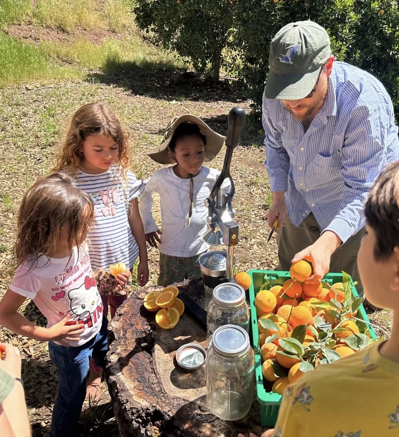 Children and a guide making fresh orange juice outdoors